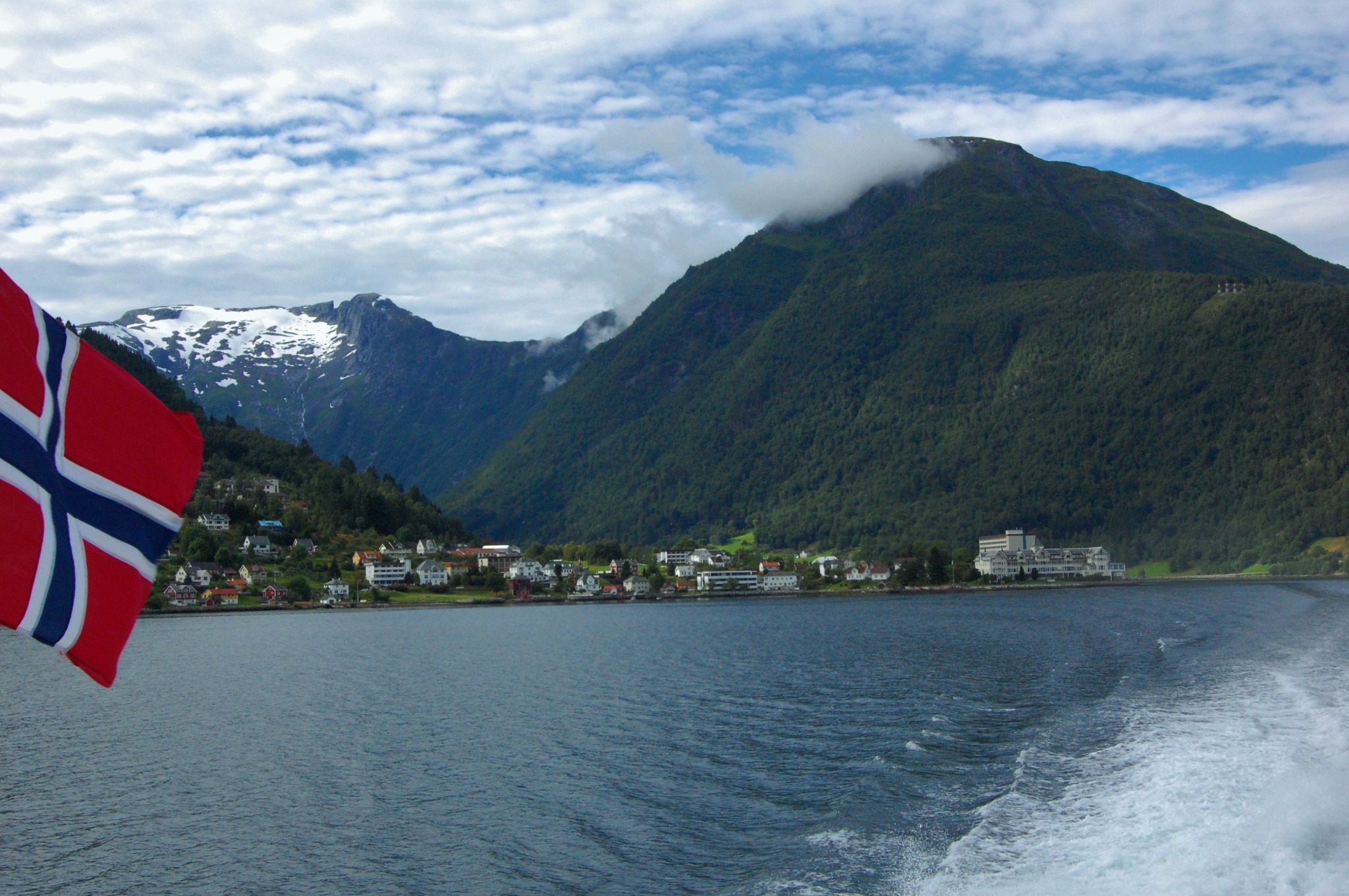 Norwegian flag on a boat approaching Balestrand across the fjord
